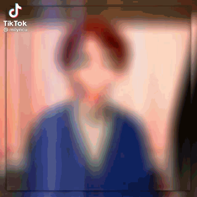 a blurry picture of a person with tiktok written on the bottom left