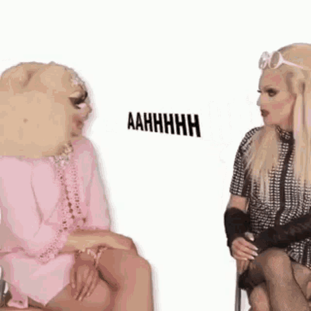 two drag queens are sitting next to each other and talking .