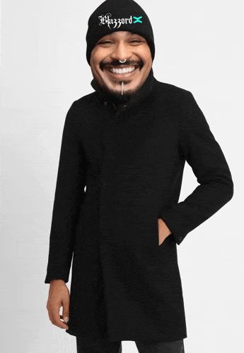 a man wearing a black coat and a beanie that says wazzord on it