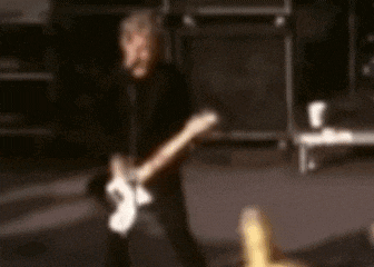a blurry picture of a man playing a guitar on a stage .