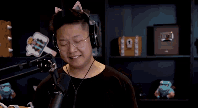 a man wearing headphones and cat ears is talking into a microphone