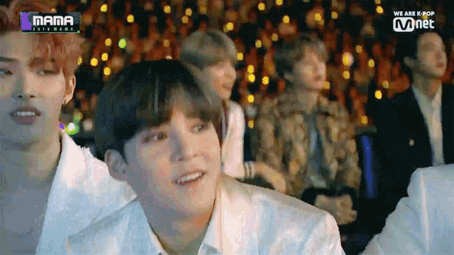a group of young men are sitting in front of a screen that says mama