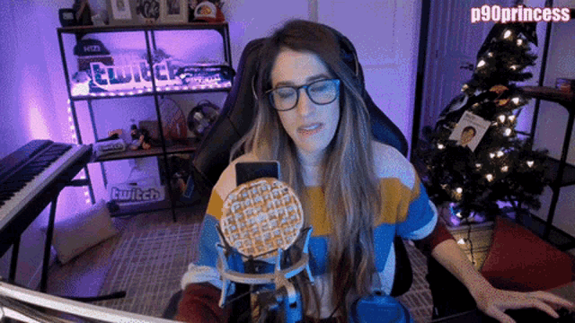 a woman sitting in front of a computer with a waffle in front of a microphone with the name p90princess on the bottom