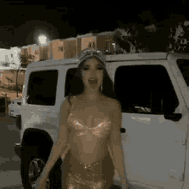 a woman in a bikini is standing in front of a white jeep .