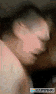 a blurred image of a man 's face with the word kapwing in the corner