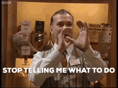 a man in a suit and tie is making a gesture with his hands while saying stop telling me what to do .