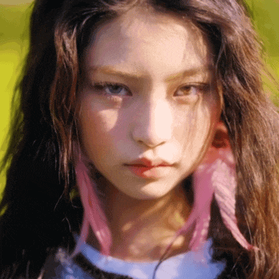 a close up of a woman 's face with pink highlights in her hair