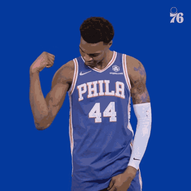 a philadelphia 76ers player flexes his arm