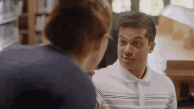 a man and a woman are talking to each other in a library
