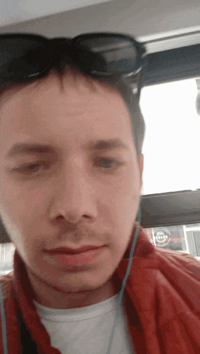 a man wearing sunglasses and ear buds is looking at the camera