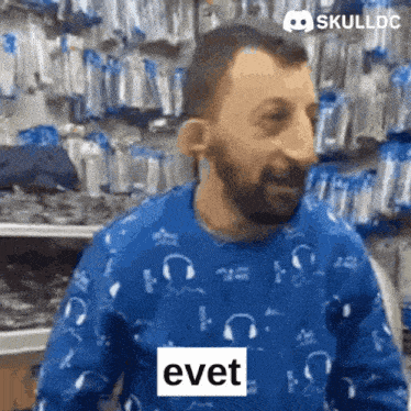 a man is wearing a blue sweater with headphones on it and says evet