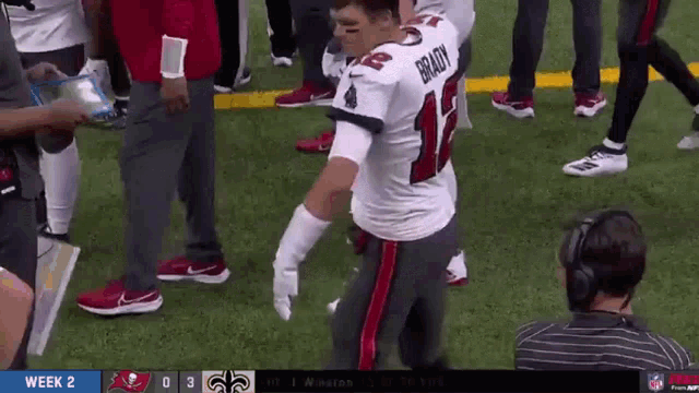 a football player named brady is kneeling down on the field