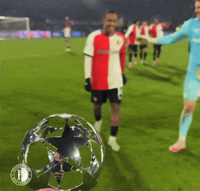 a soccer player in a red and white shirt is kicking a trophy with the letter f on it
