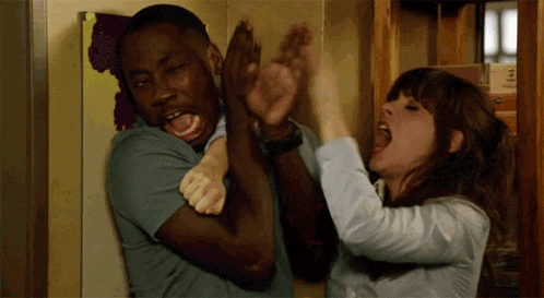 a woman is holding a man 's arm while he screams