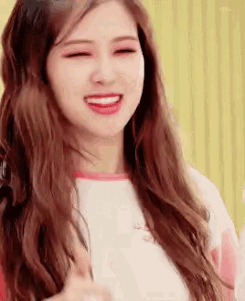 a woman with long brown hair is smiling and giving a high five .