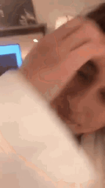 a close up of a person 's face with their hand on it .