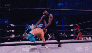 a wrestler is kneeling down in a ring with the word live on the screen