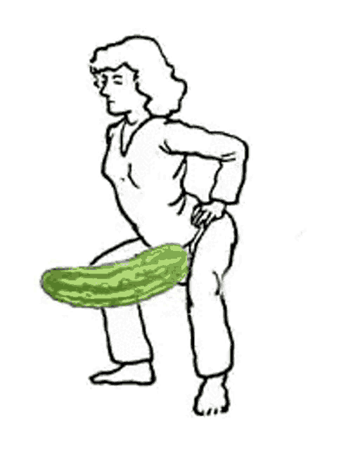 a woman is kneeling down with a cucumber sticking out of her leg .