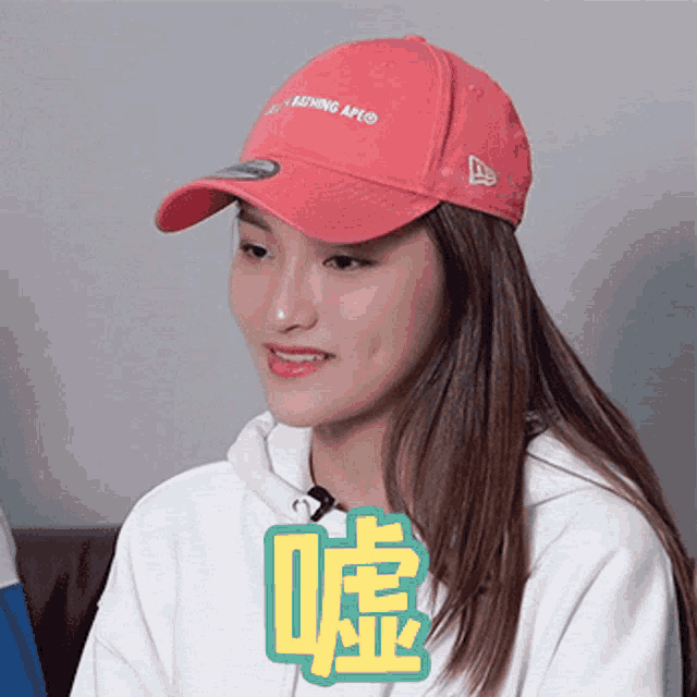 a woman wearing a pink hat that says " a bathing ape "