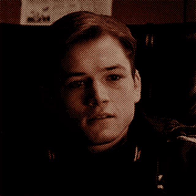 a close up of a man 's face with his eyes closed in a dark room