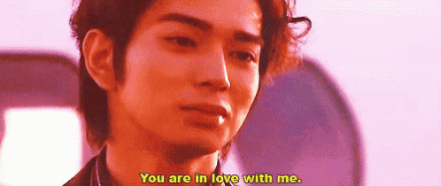 a man is saying `` you are in love with me '' while smoking a cigarette .