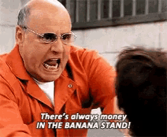 a man in an orange jumpsuit is yelling at another man and says there 's always money in the banana stand !