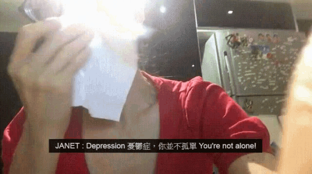a woman in a red shirt is holding a napkin in front of her face and a sign that says janet depression on it