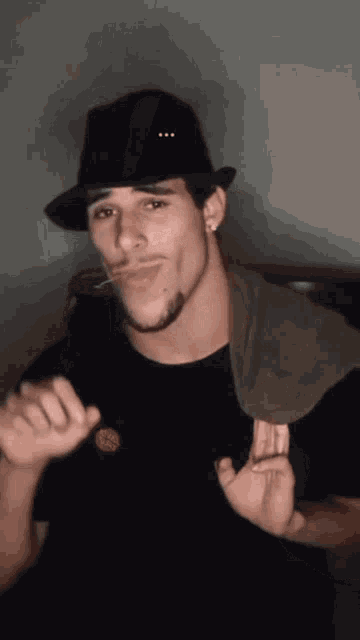a man wearing a black hat and a black shirt with a santa cruz badge on it