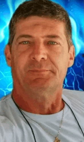a man with a necklace around his neck is looking at the camera .