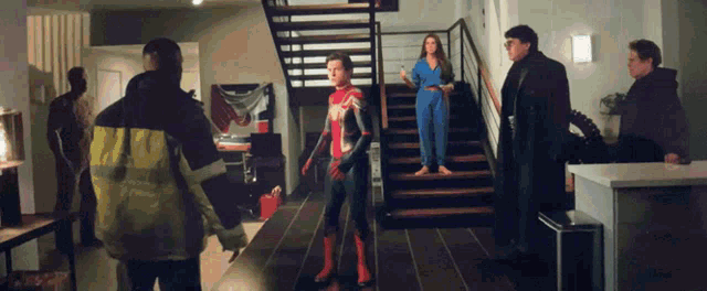 a man in a spiderman costume stands in front of stairs
