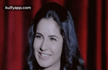 a close up of a woman laughing with her eyes closed .
