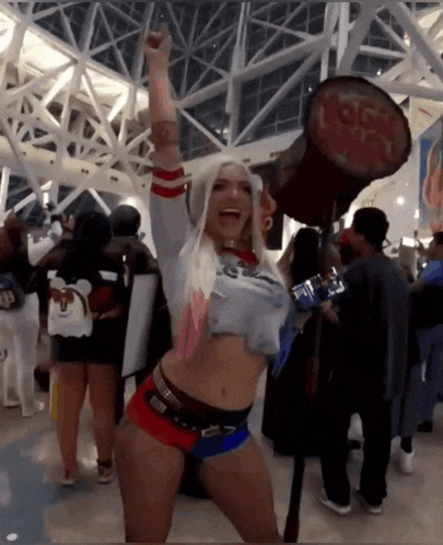 a woman in a harley quinn costume is holding a hammer