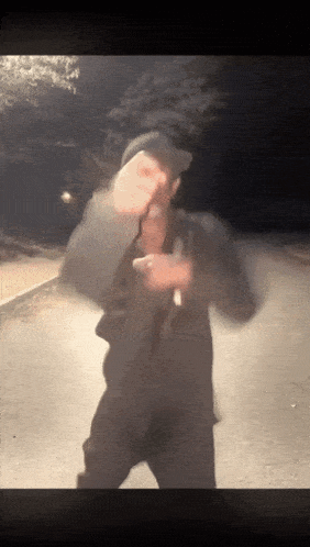 a blurry picture of a person standing on a street at night
