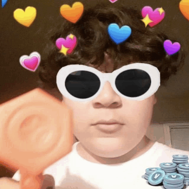 a young boy wearing sunglasses and hearts on his head