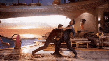 two men are fighting in a living room with a statue of a woman in the background