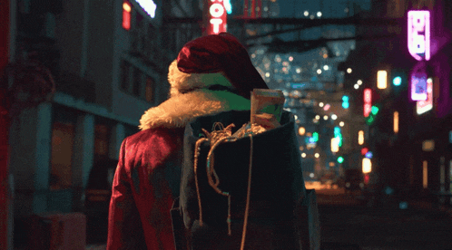 a person wearing a santa hat carrying a bag of gifts