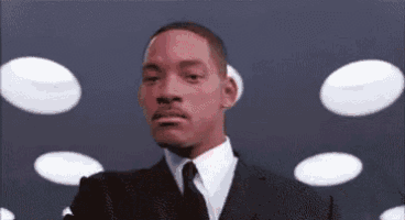 a man in a suit and tie is standing in front of a bunch of white dots .
