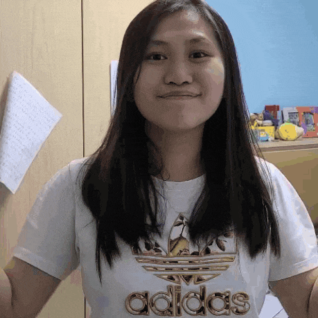 a woman wearing a white adidas t-shirt smiles for the camera