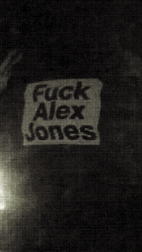 a sign that says " fuck alex jones " is on a wall