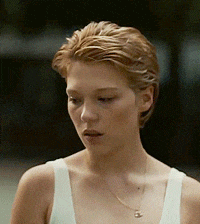 a close up of a woman wearing a white tank top and necklace