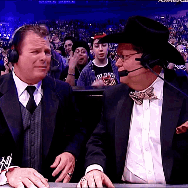 a man in a cowboy hat talks to another man in a suit