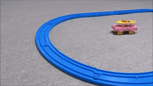 a blue toy train is going down a track