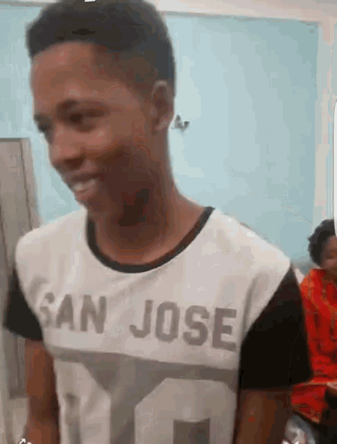 a man wearing a shirt that says san jose is smiling