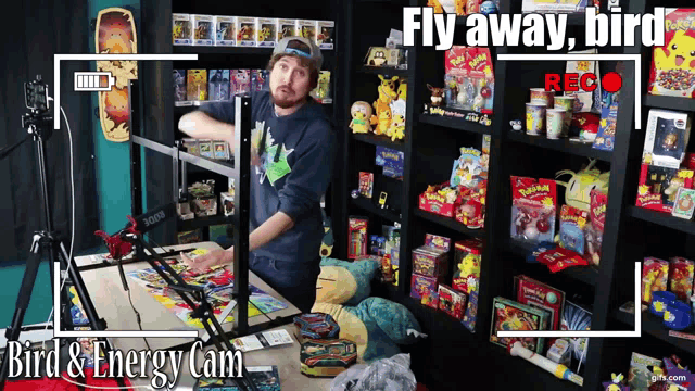 a man is standing in front of a shelf full of toys and the words fly away bird are visible