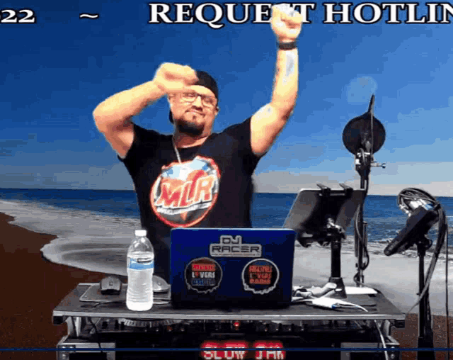 a man is standing in front of a laptop that says dj racer