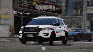 a white ford police car is parked in front of a store called souvenir