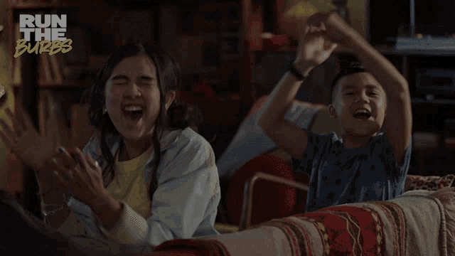 a boy and a girl are sitting on a couch with the words run the burbs on the bottom right