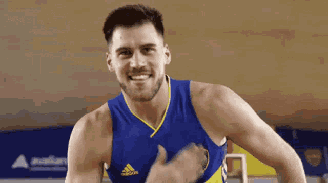 a man is wearing a blue and yellow tank top with the word cabj on it