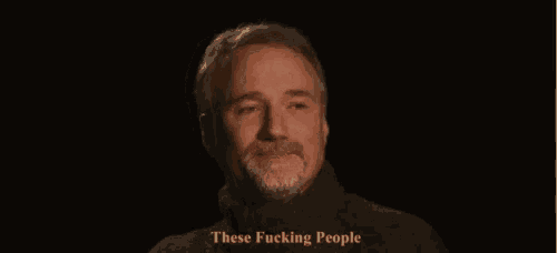 a man with a beard is wearing a black turtleneck sweater and says these fucking people