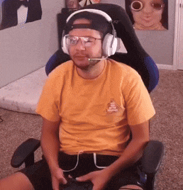 a man wearing headphones and glasses is sitting in a chair .